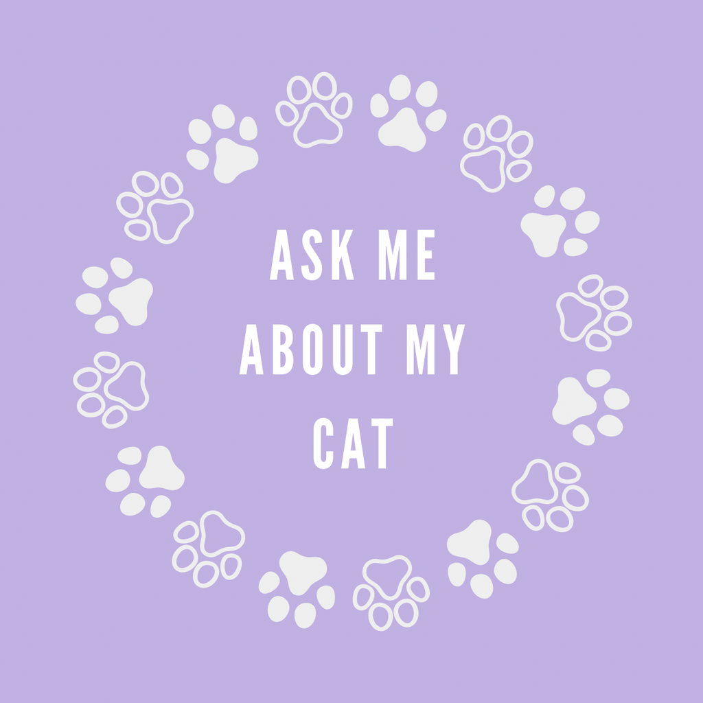 A round, 2-inch fridge magnet featuring a purple background with white paw prints circling text that reads, 'Ask me about my cat'