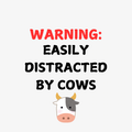 A round, 2-inch fridge magnet with cartoon cow with text 'WARNING: EASILY DISTRACTED BY COWS' on a white background