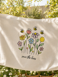Beige fabric tote bag with floral design and 'save the bees' text.